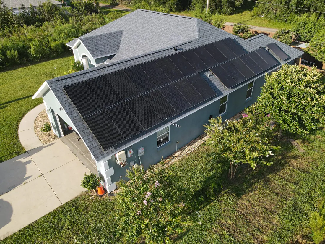 Aerial drone view of a completed residential solar panel installation on an asphalt shingle roof in Orlando, FL